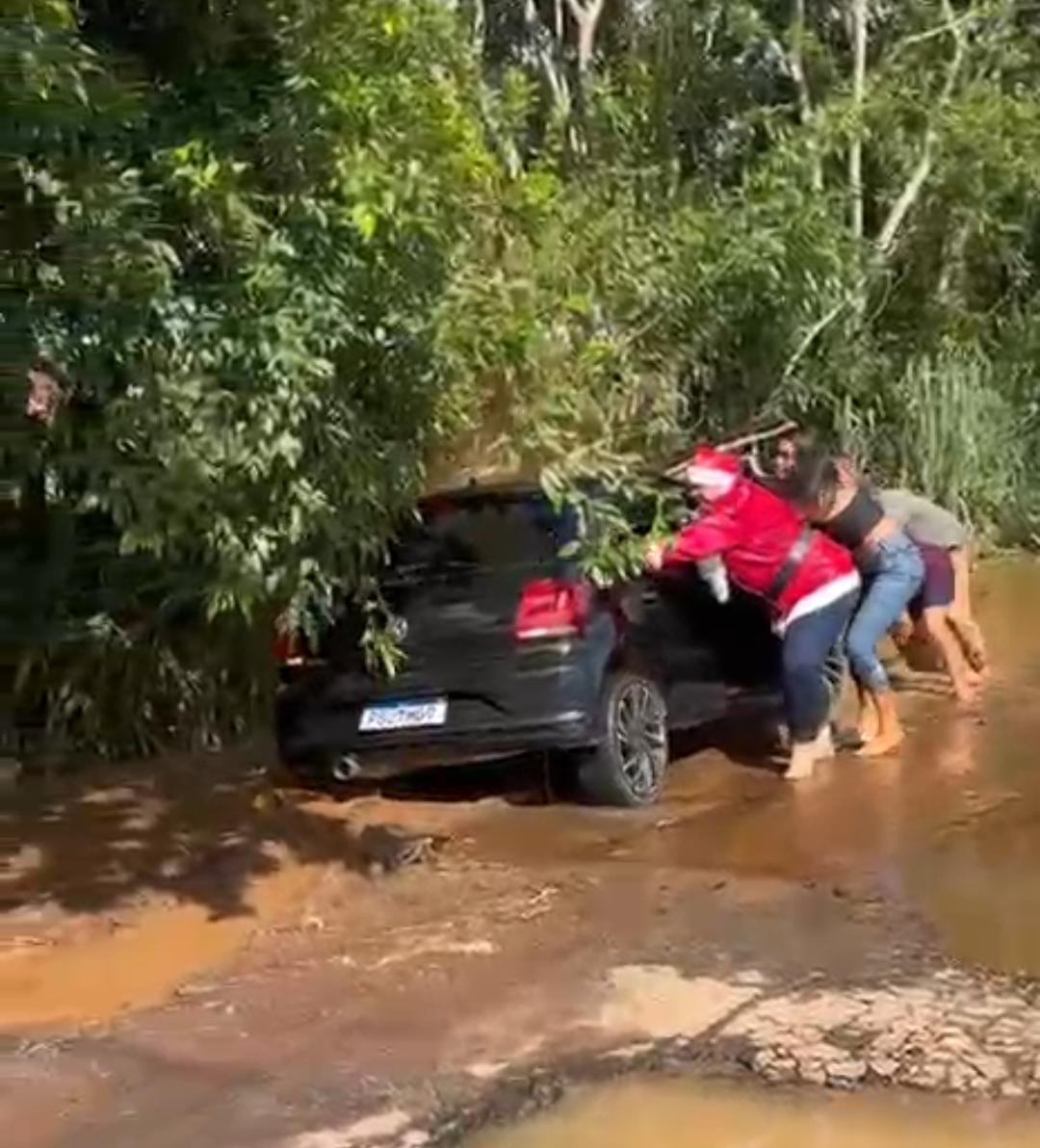 Mamãe Noel ajuda a desatolar carro durante ação solidária em área alagada de Rio Branco